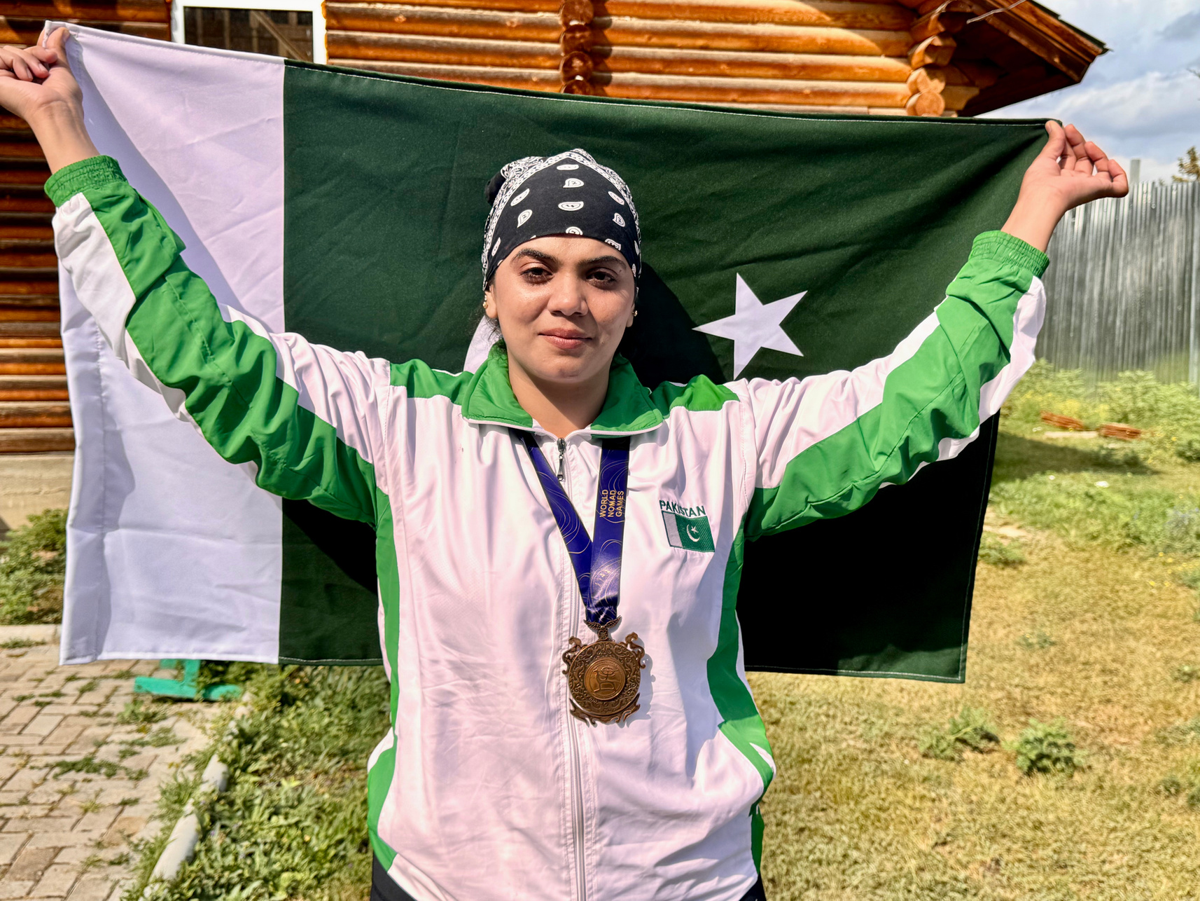 Iqra Naseeb celebrating with the Pakistan flag and bronze medal