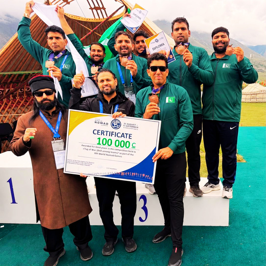 Pakistan Tug of War 8x8 team on the podium with their bronze medal certificate